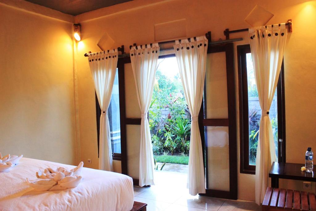a bedroom with a bed and a large window at Menjangan Sari in Banyuwedang