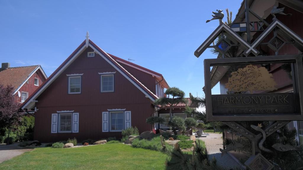 a home with a sign for a happy driveway park at Harmony Park Nida House in Nida