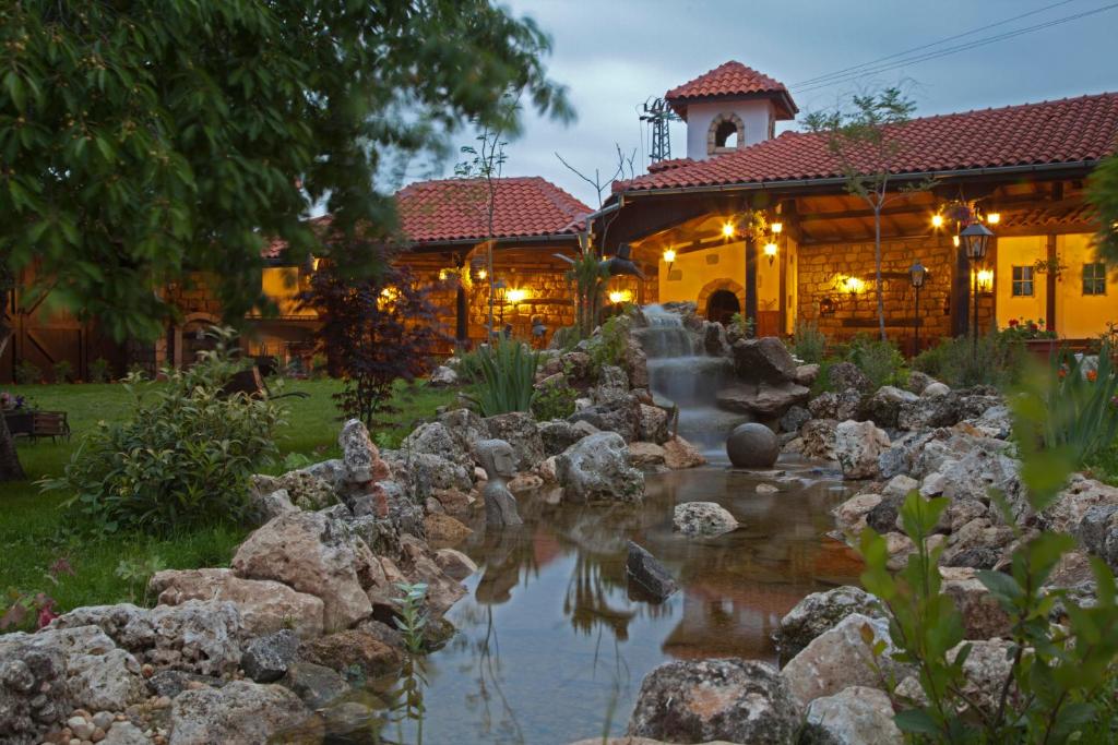 a house with a pond in front of a building at Villa Bulgara Eco in Madara