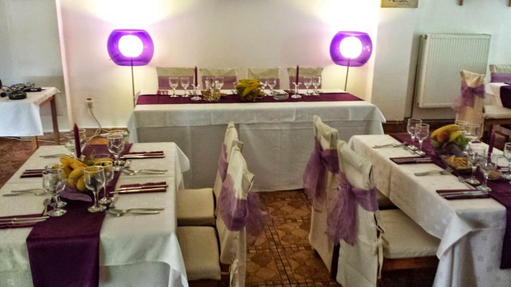 a dining room with two tables with white tablecloths at Floarea Soarelui in Cheia