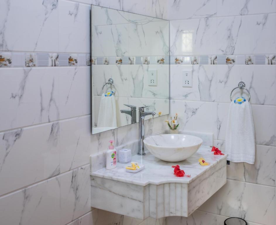 bagno bianco con lavandino e specchio di Seashell Beach Villa a Grand'Anse Praslin