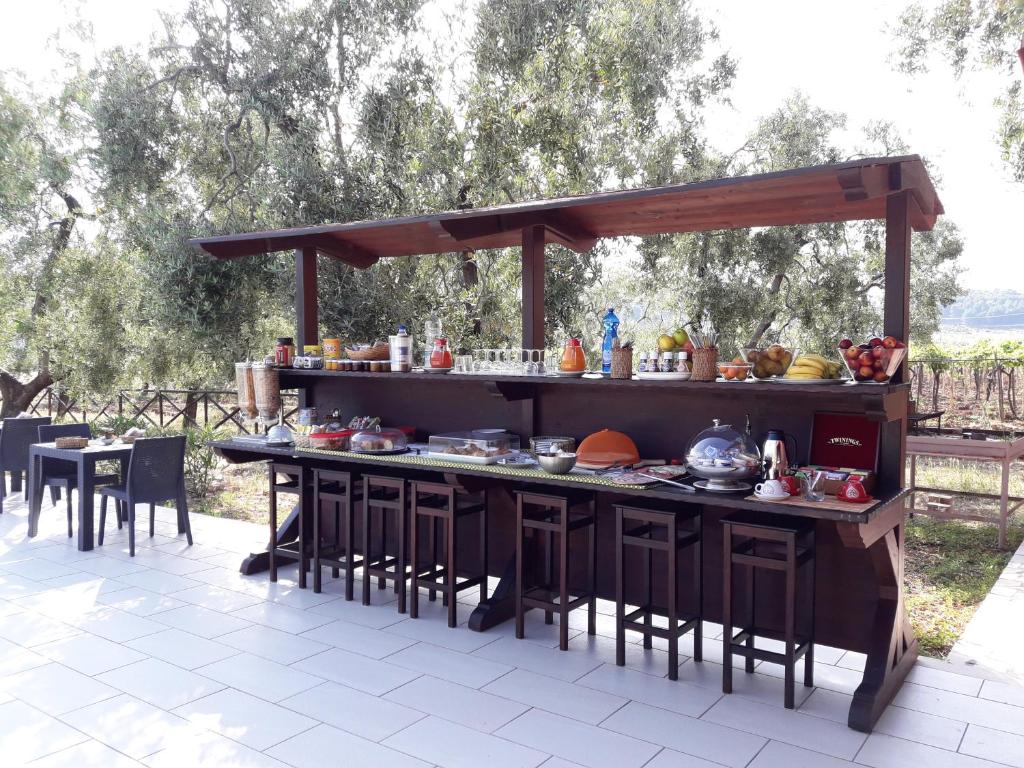 kuchnia na świeżym powietrzu ze stołem i krzesłami w obiekcie Agriturismo Posta Pastorella w mieście Vieste