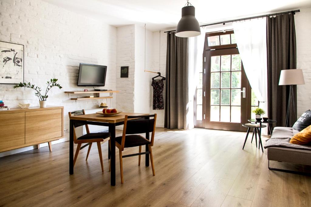 ein Wohnzimmer mit einem Tisch, Stühlen und einem Sofa in der Unterkunft Garden Studio in Krakau
