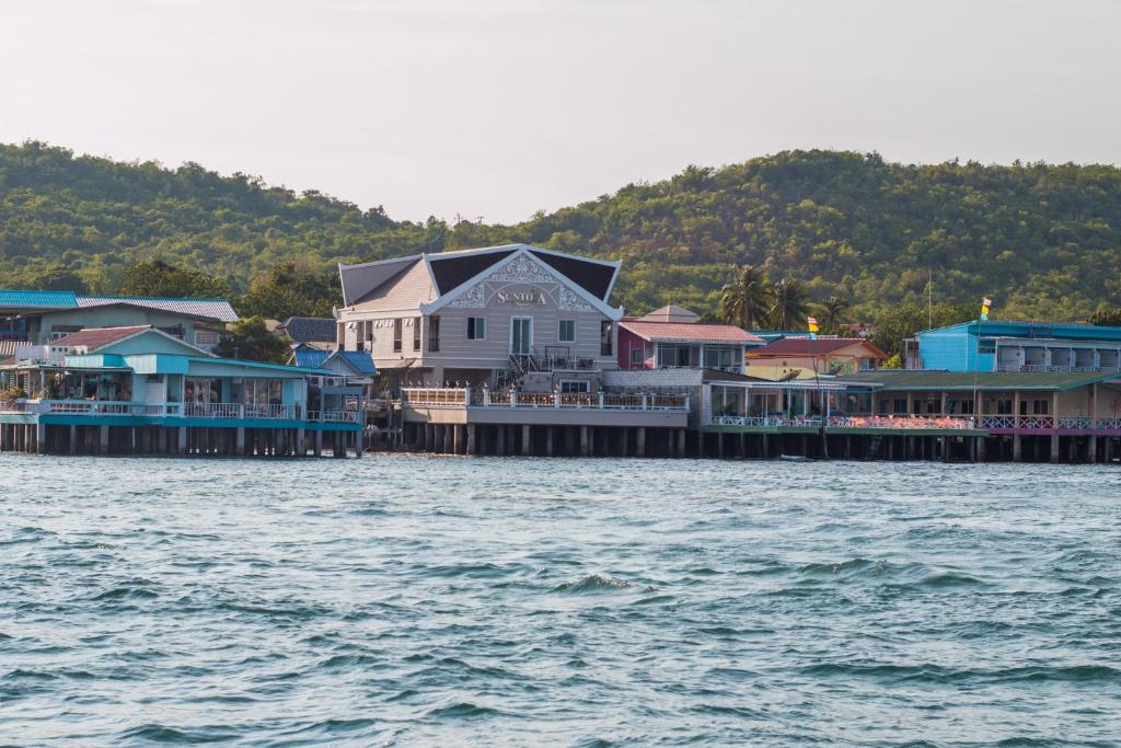 a group of houses on a dock on the water at Suntosa Resort in Ko Larn