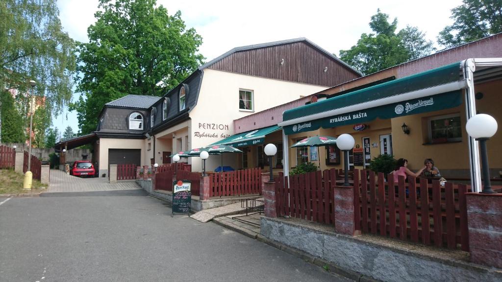 een gebouw met een rood hek voor een straat bij Pension Rybářská Bašta in Jablonec nad Nisou