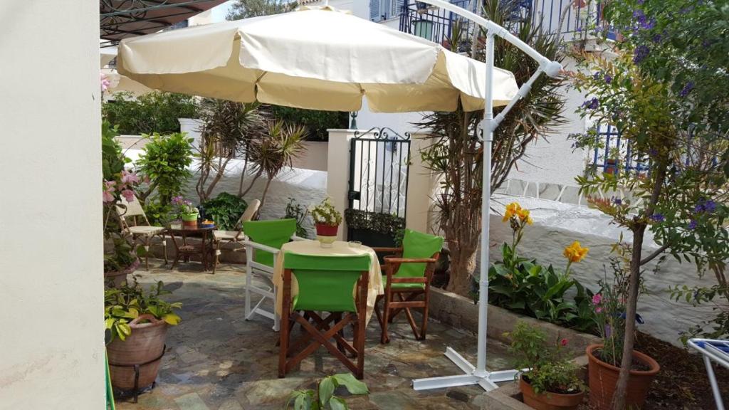 a table and chairs under an umbrella on a patio at Toula's House in Spetses