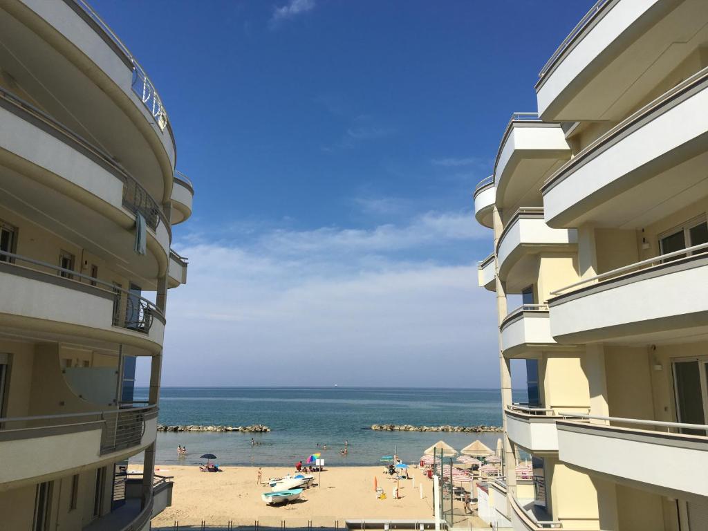 フランカヴィッラ・アル・マーレにあるStella Del Mare Privatoの2棟の建物の間からビーチの景色を望めます。