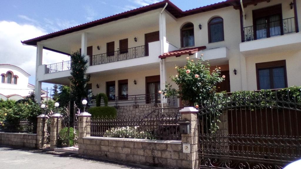 uma casa branca com uma cerca à frente. em Hotel Archontiko Dimitra em Vergina