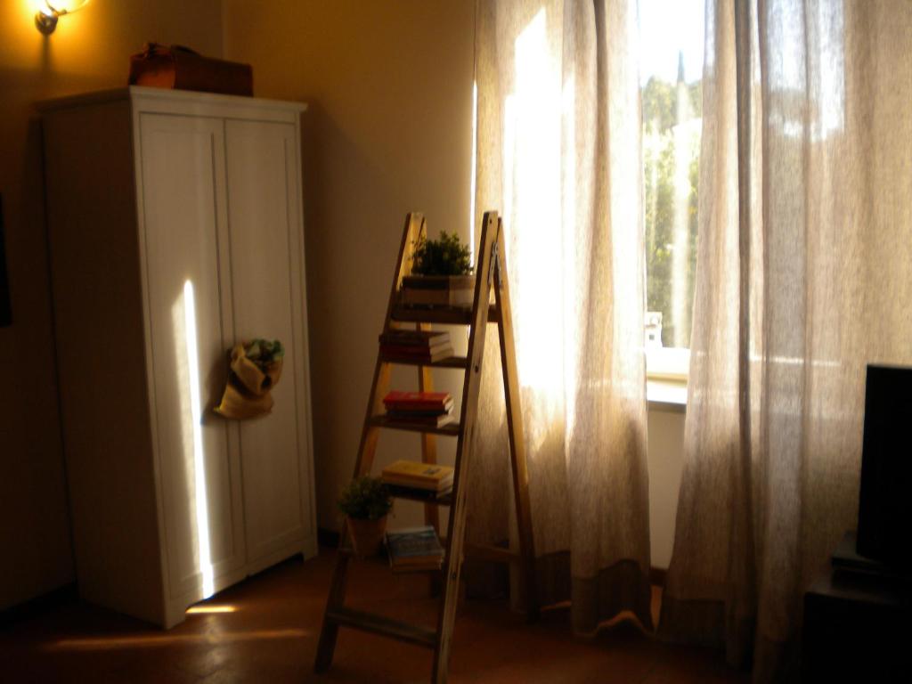Habitación con escalera y ventana con cortinas. en La Torta Di Mele, en Bérgamo