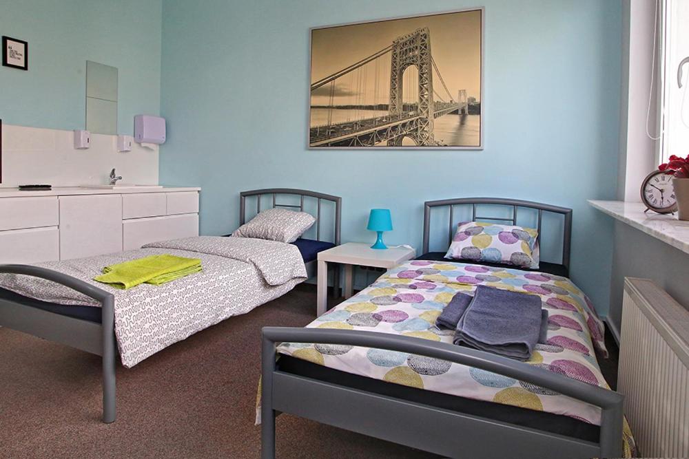 1 dormitorio con 2 camas y un puente en la pared en HELLO Gdynia Hostel, en Gdynia