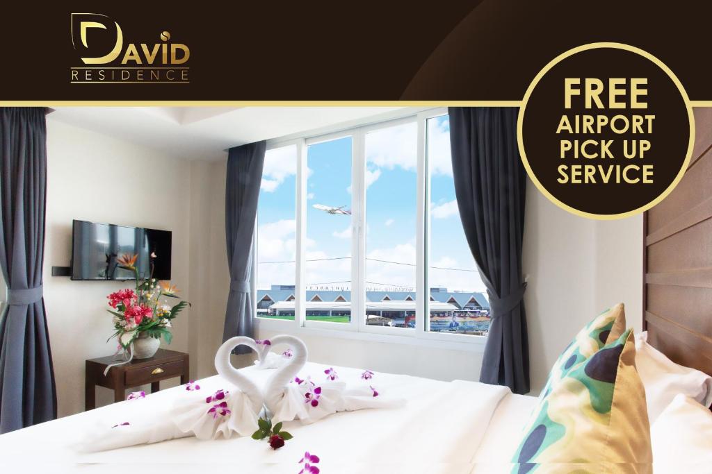 a poster for a hotel room with two swans on a bed at David Residence in Nai Yang Beach