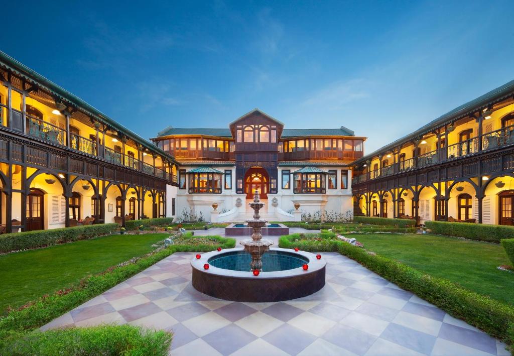 a large building with a fountain in a courtyard at Welcomhotel by ITC Hotels, The Savoy, Mussoorie in Mussoorie