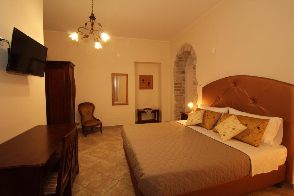 a bedroom with a bed and a desk and a television at Palazzo 1892 Guest House in Castelvetere in Val Fortore