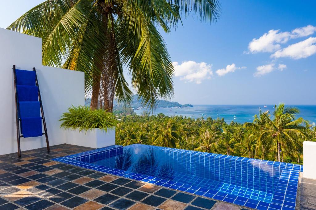 a resort swimming pool with a view of the ocean at The Plantation Koh Tao in Koh Tao