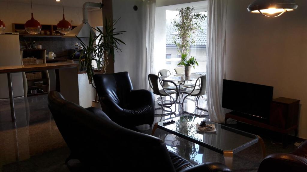 sala de estar con mesa de cristal y sillas negras en Vilnius Luxury Apartment 1 en Vilna