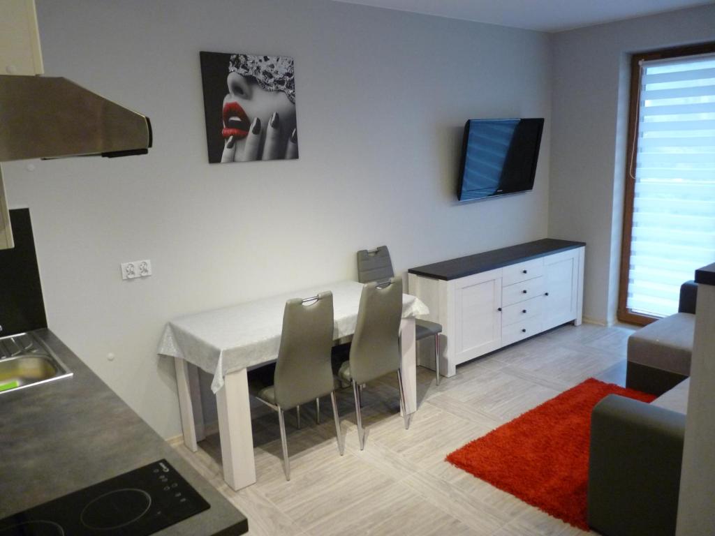 - un salon avec une table et des chaises blanches dans l'établissement Apartament Sandra, à Karpacz