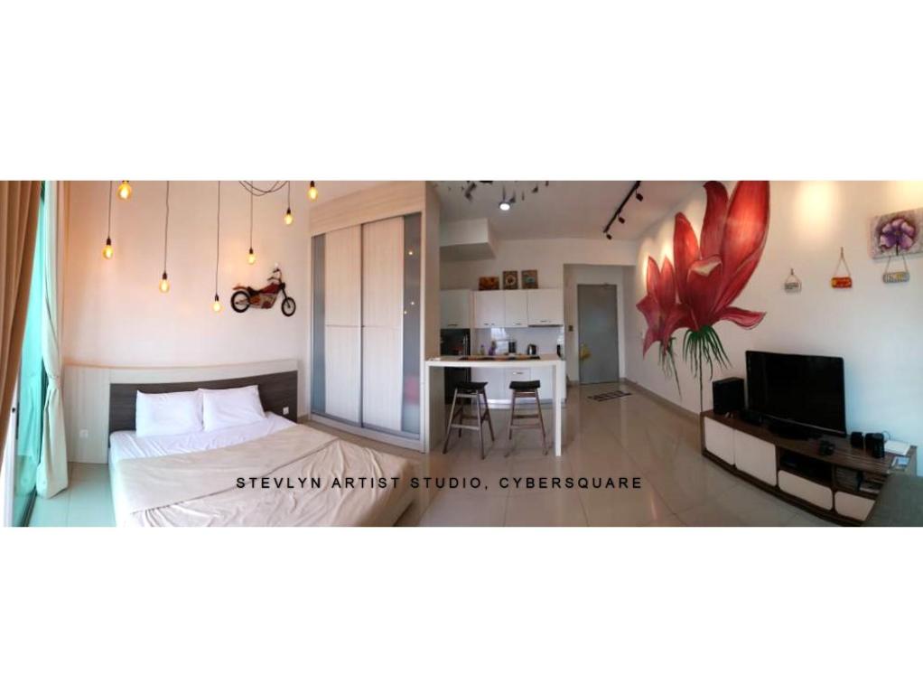 a bedroom with a bed and a kitchen with a table at Stevlyn Artist Studio in Cyberjaya