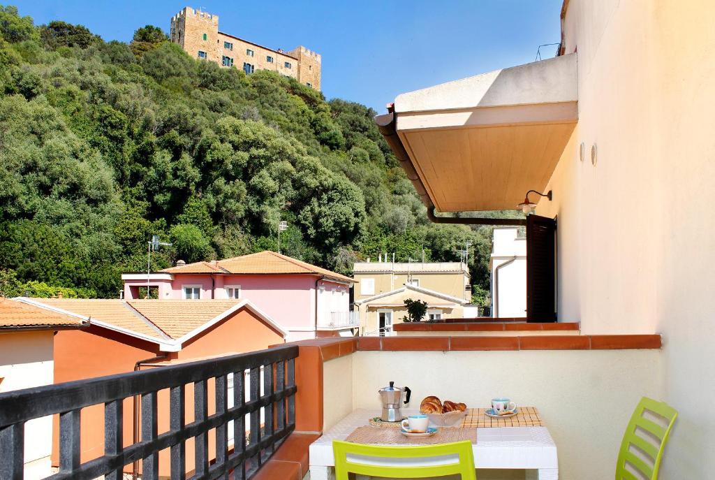 einen Balkon mit einem Tisch und Stühlen auf einem Gebäude in der Unterkunft Residence Teclini in Castiglione della Pescaia