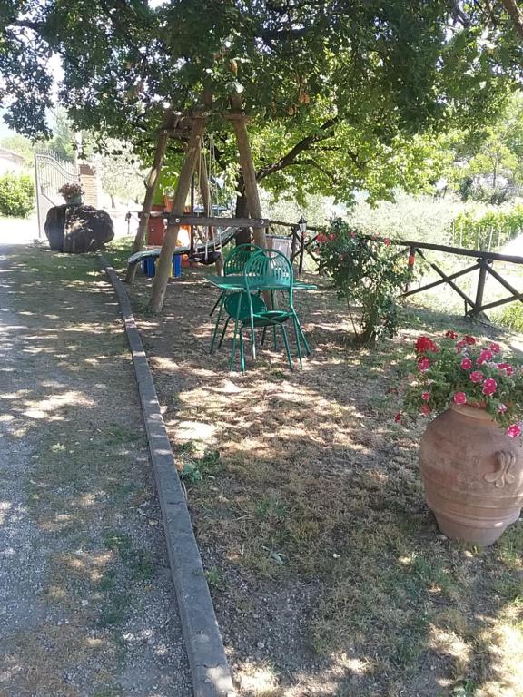 einen Park mit einem Spielplatz mit einem Tisch und einer Schaukel in der Unterkunft Il Casale della Quercia in Assisi
