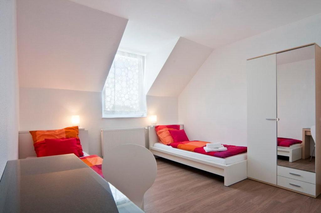 a small room with a bed and a mirror at Bed & Breakfast BonnaNotte in Essen