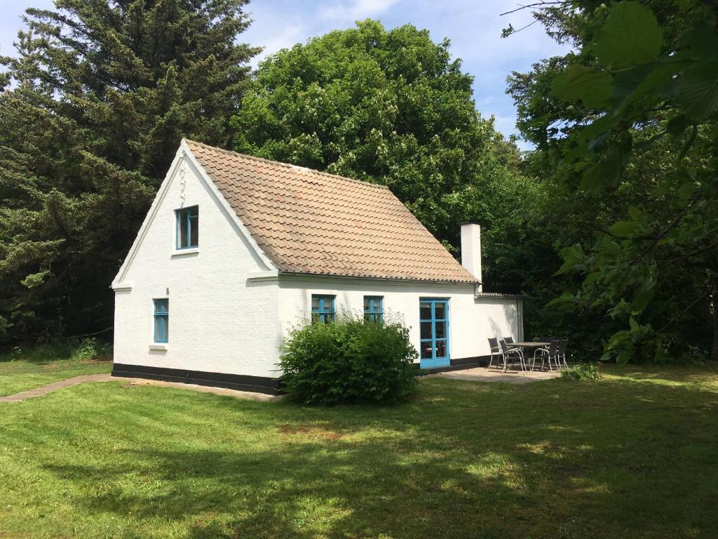 ein weißes Haus mit einem Picknicktisch im Hof in der Unterkunft Skovhuset in Uggerby