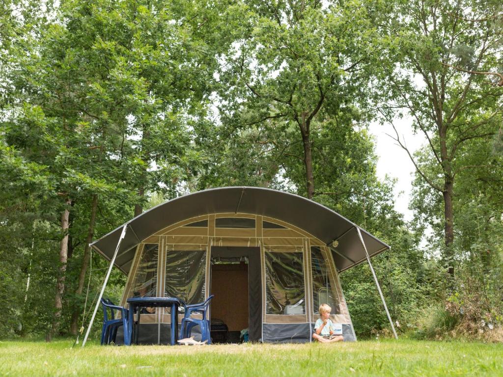 een vrouw die voor een tent in het gras zit bij Country Camp camping de Gulperberg in Gulpen