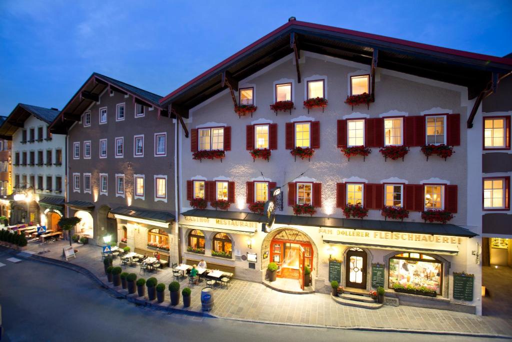 a large building with tables and chairs in front of it at Genießerhotel Döllerer in Golling an der Salzach