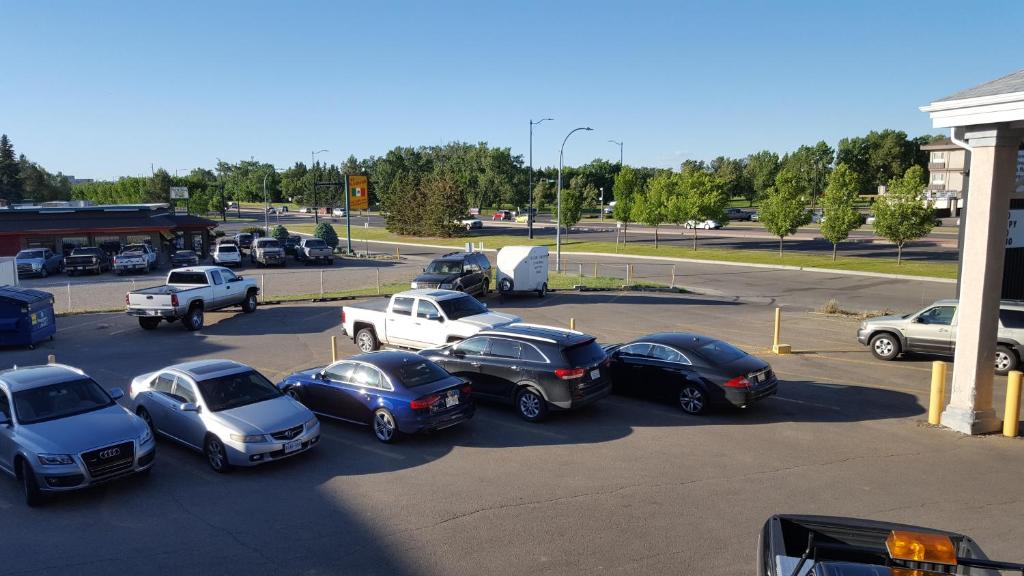 a group of cars parked in a parking lot at Knights Inn Lethbridge in Lethbridge