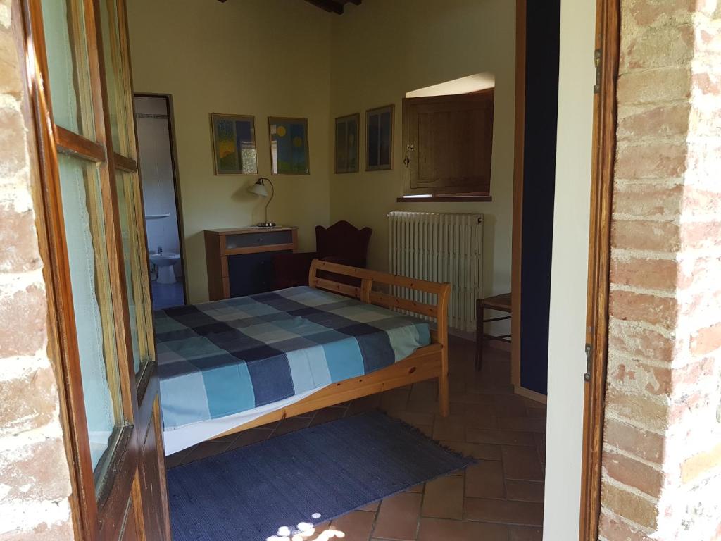 małą sypialnię z łóżkiem w pokoju w obiekcie Villa La Torricella w mieście Monte San Savino