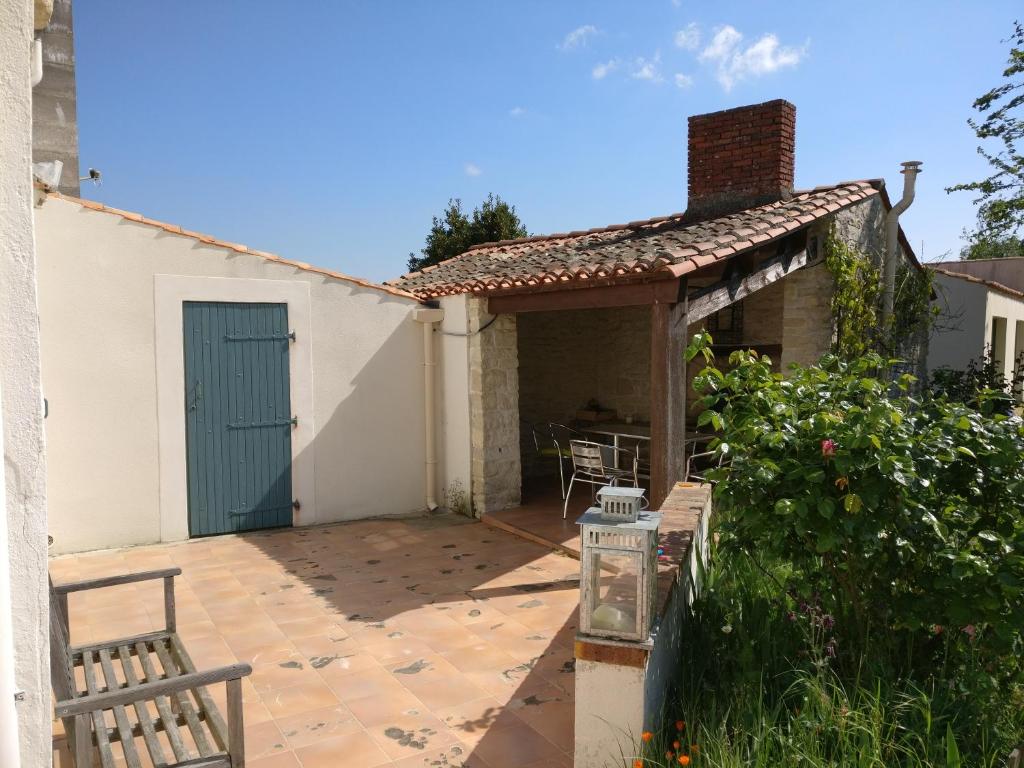 a patio with a blue door and a building at Des Km à La Ronde in La Ronde