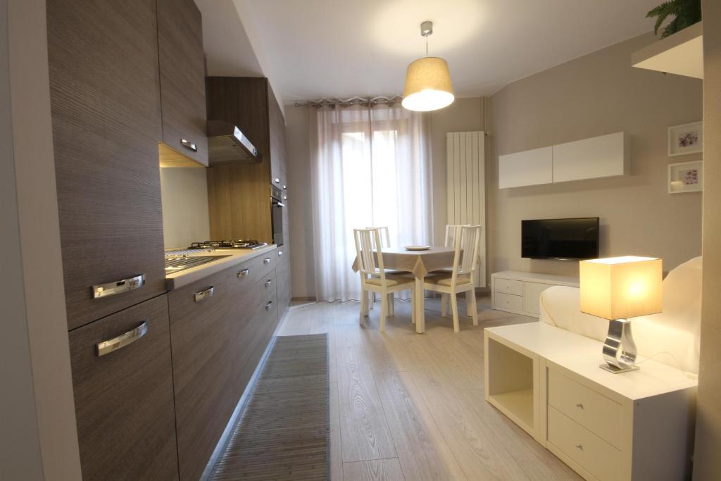 a kitchen and living room with a table and a couch at Appartamenti al Rizzo dei Santi in Lovere