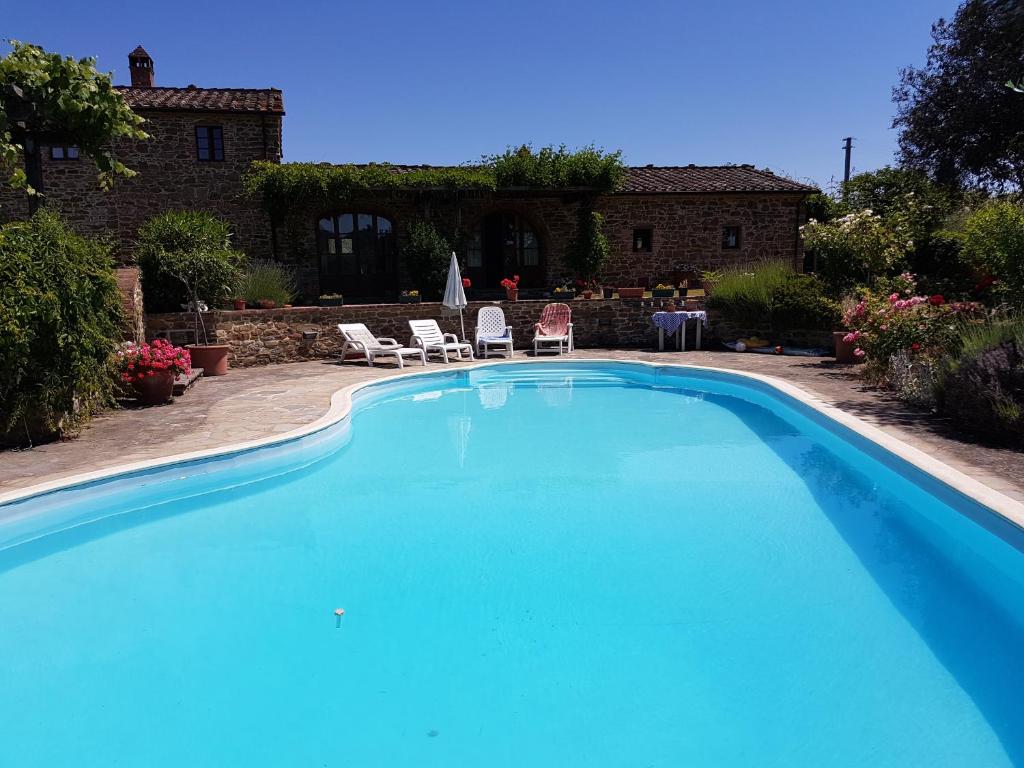 duży niebieski basen przed domem w obiekcie Villa La Torricella w mieście Monte San Savino