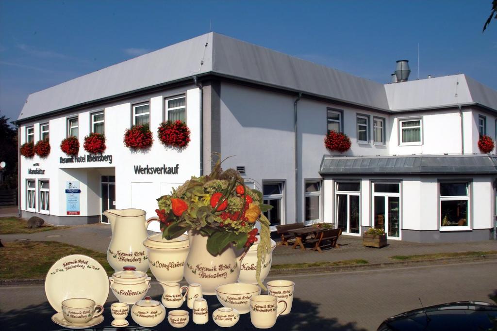 a white building with flower pots in front of it at Keramik Hotel Rheinsberg in Rheinsberg