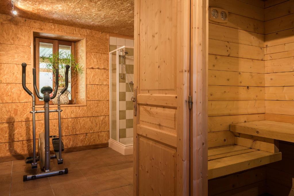 a sauna with a bench and a shower in a room at Le Moulin Berthon in Vernusse