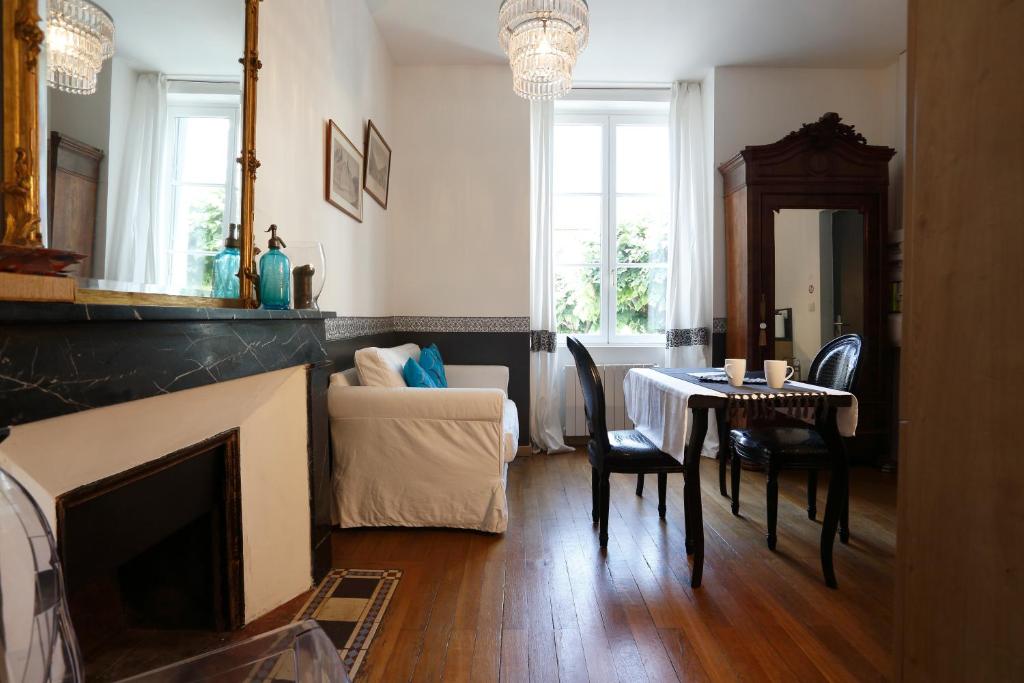 a living room with a fireplace and a table and chairs at Nature & Chateaux in Chinon