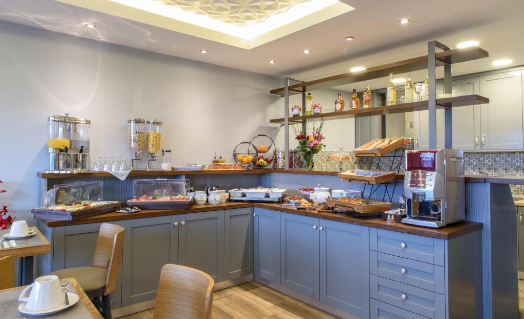 una cocina con armarios azules y una barra con comida en Athos Thea Luxury Rooms en Sárti