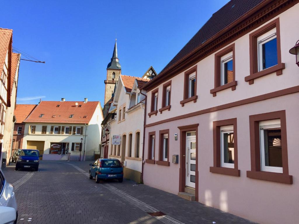 una calle en una ciudad con una torre de reloj en Villa Kerzenheimer Tor, en Göllheim