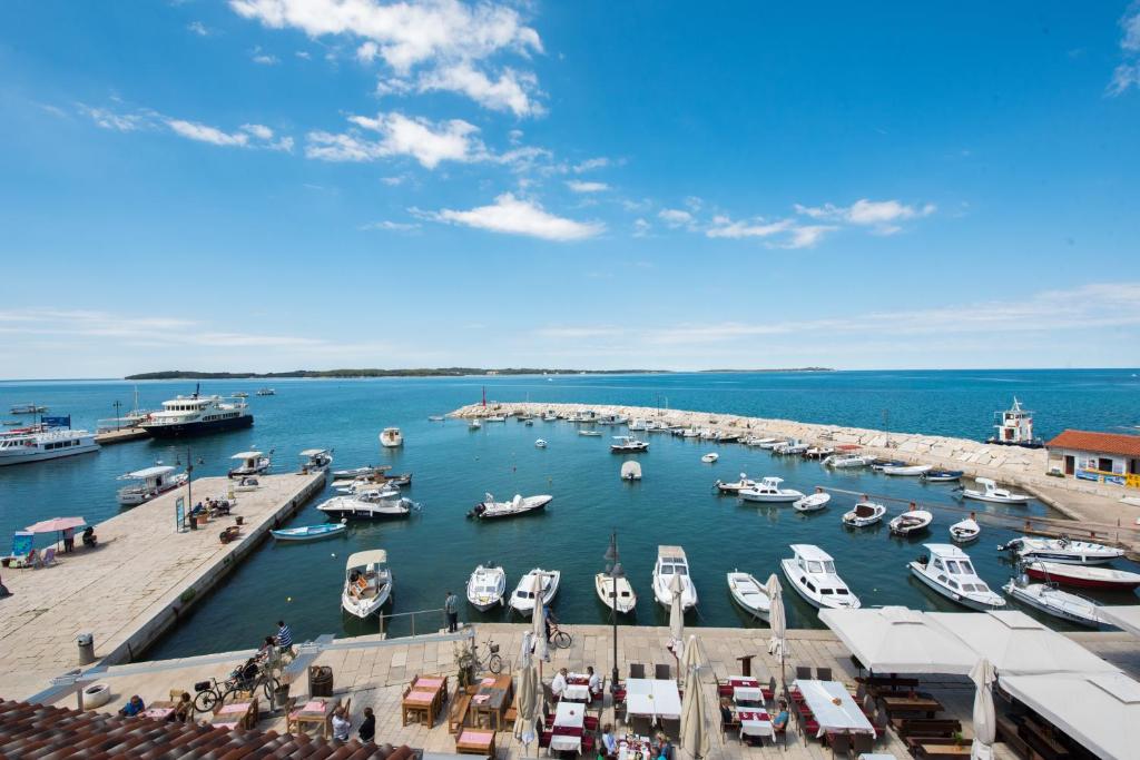 un port rempli de nombreux bateaux dans l'eau dans l'établissement Hotel Marina, à Fažana