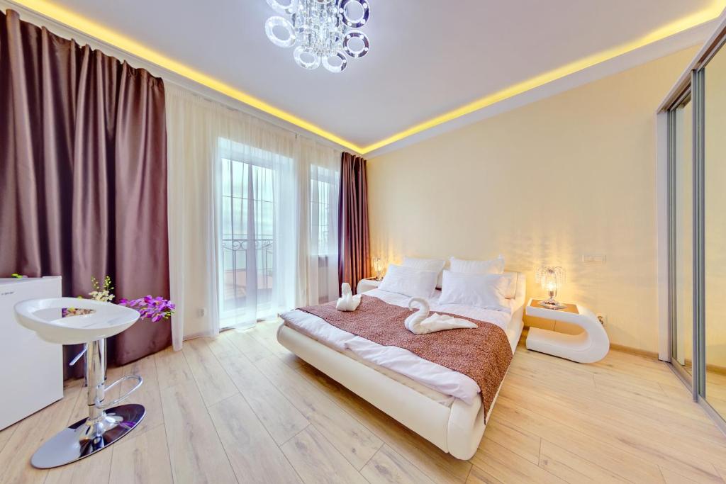 a bedroom with a large bed and a chandelier at Apartments Exclusive in Zelenogradsk