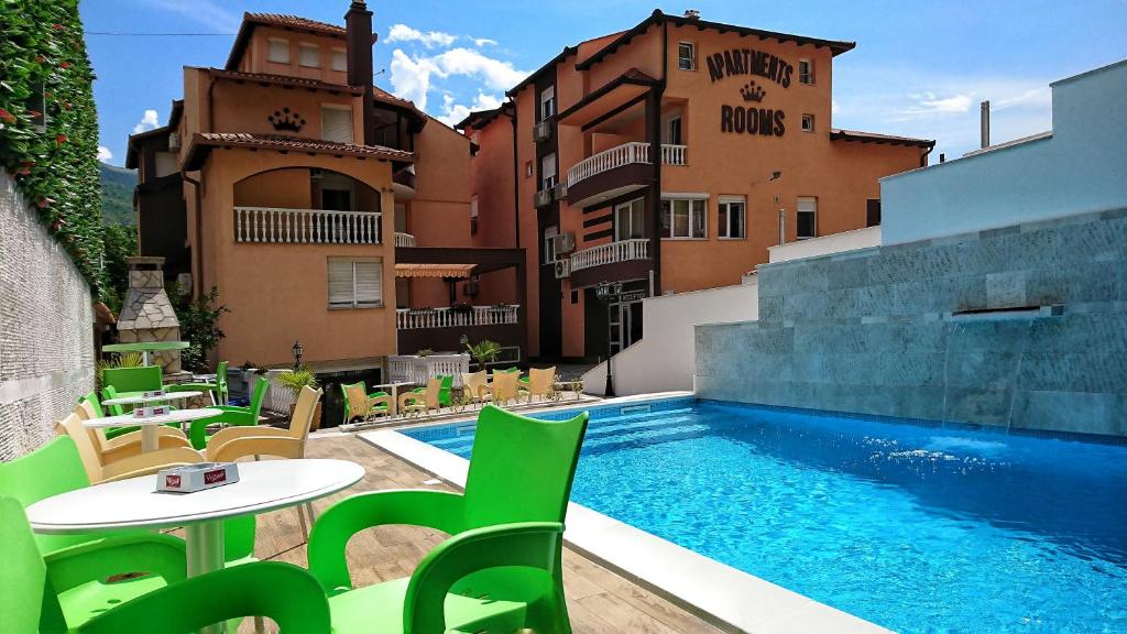 a pool with a table and chairs next to a building at Hotel Villa Nadin in Mostar