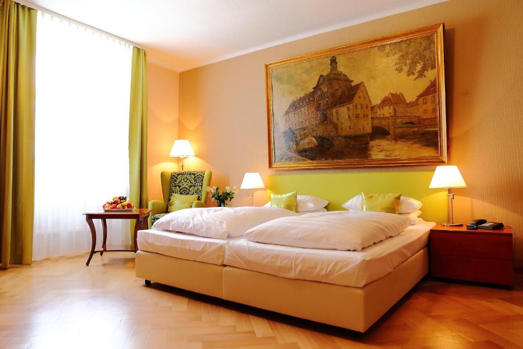 1 dormitorio con 1 cama y una pintura en la pared en Hotel Rappensberger en Ingolstadt