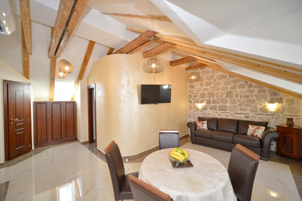 ein Wohnzimmer mit einem Tisch und einem Sofa in der Unterkunft Palazzo Max and Alex Apartments in Kotor