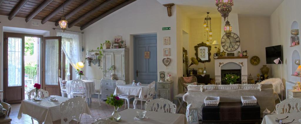 una sala da pranzo con tavoli bianchi e sedie bianche di Casona Del Duende ad Alájar