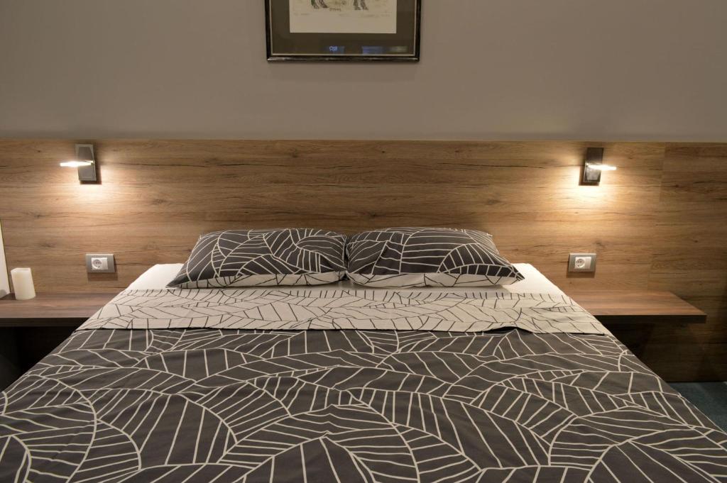 um quarto com uma cama grande e uma cabeceira em madeira em Apartment Millas em Niš