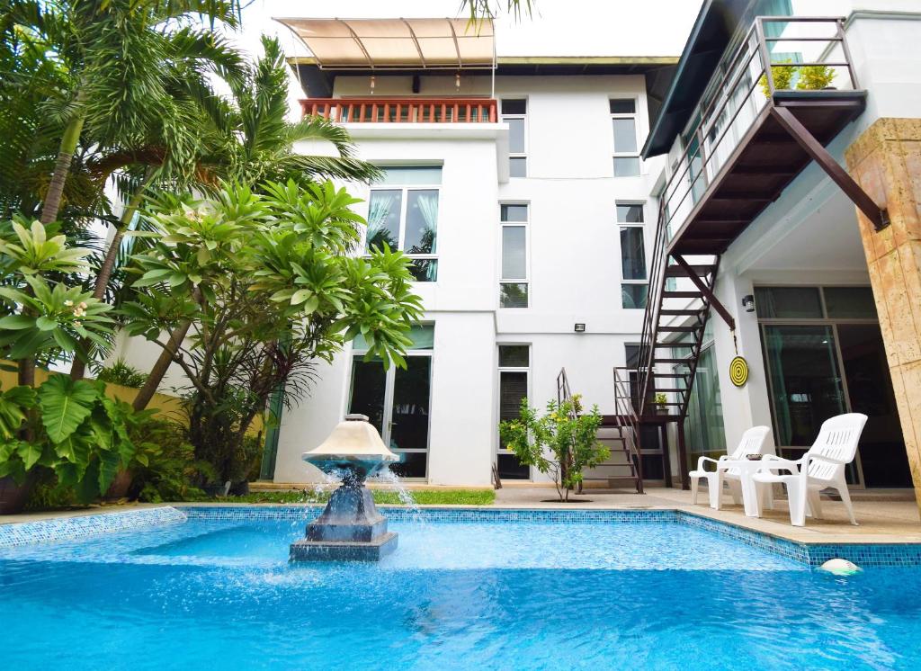 una piscina frente a una casa con una fuente en Tropical Garden Paradise Villa, en Na Jomtien