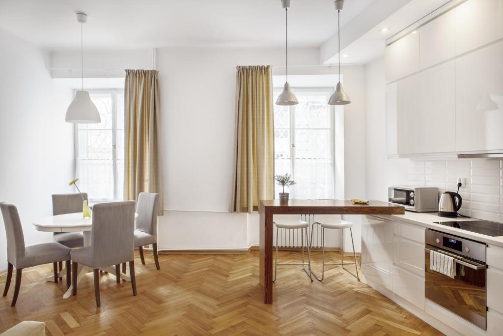 a kitchen and dining room with a table and chairs at Bednarska Old Town Apartment in Warsaw