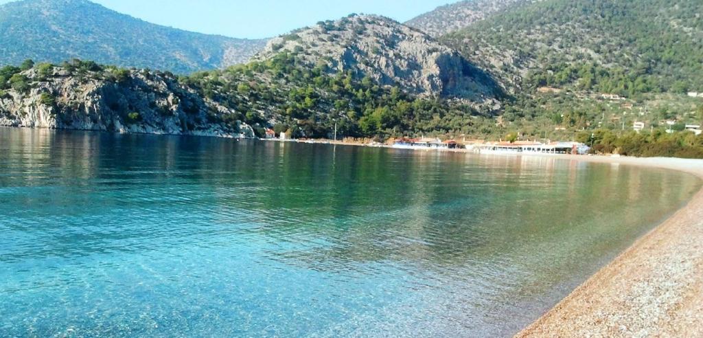 a view of a beach with mountains in the background at Beachfront self-catering studios in Psatha Bay - 60km from Athens in Psatha