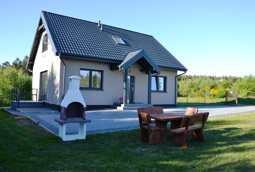 a small house with a fireplace in the yard at Dom wakacyjny Albert in Mieroszyno