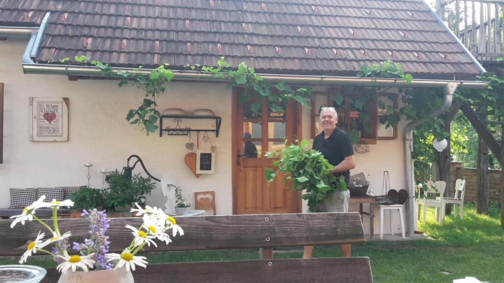 Ein Mann steht vor einem Haus. in der Unterkunft Herzlhof Rupp in Unterschwarza