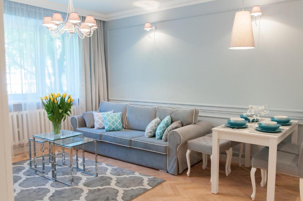 a living room with a blue couch and a table at Apartament Karmelicka 11 in Warsaw